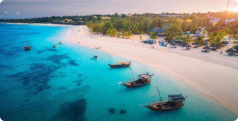Widok z lotu ptaka na lazurową lagunę z łódkami i białą plażą na Zanzibarze